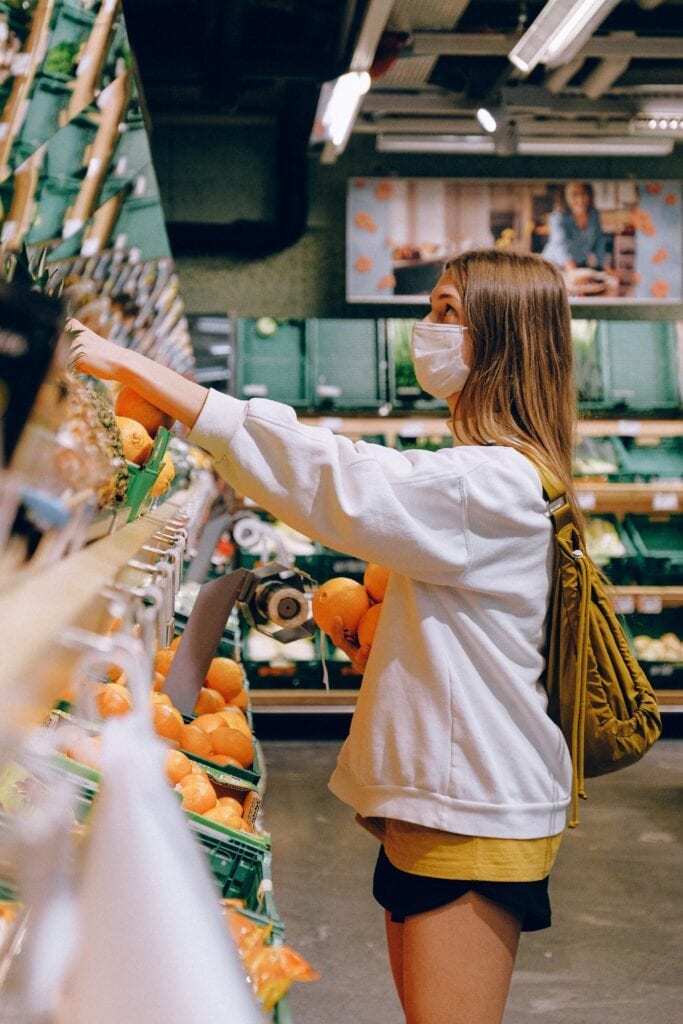 Woman buying oranges at a grocery store